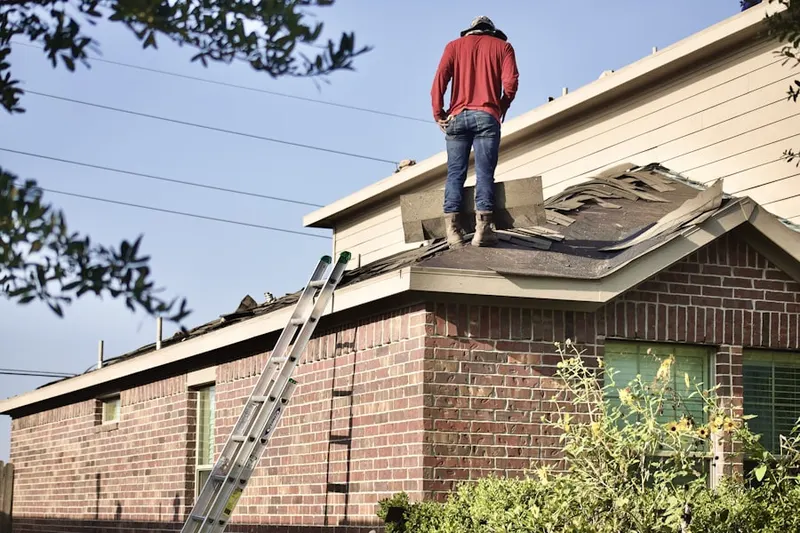 Professional roofer working on a residential roof in Coventry Square